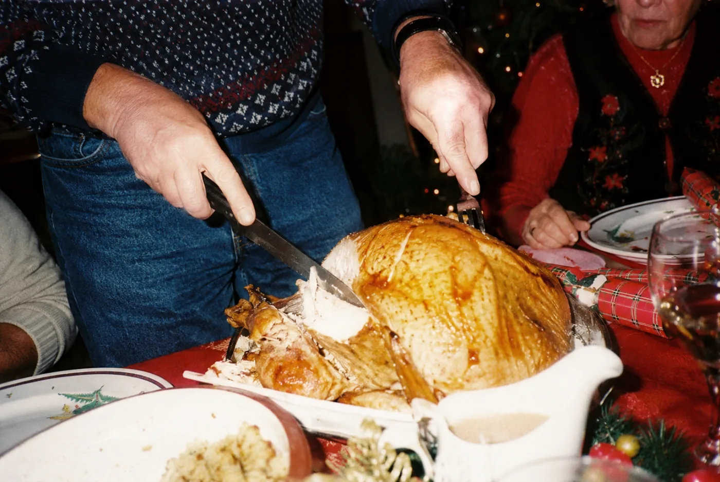 A family gathered around the table at a warm holiday Christmas dinner