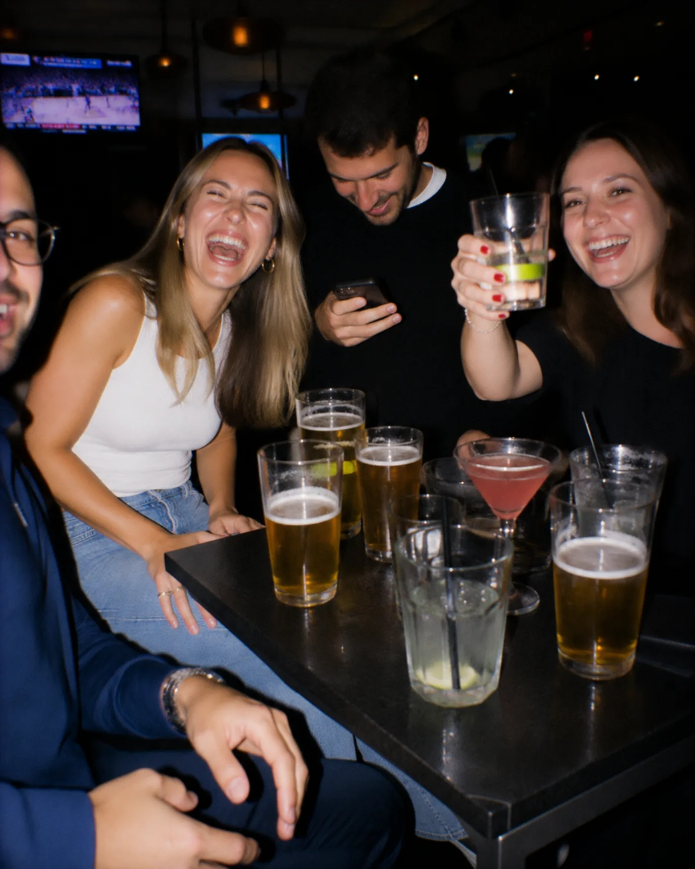 Amigos reunidos alrededor de una mesa en un bar de after office