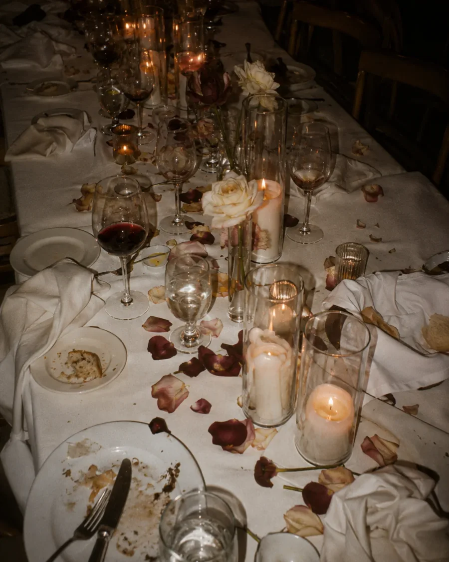 Mesa de boda con velas y pétalos, en penumbra, vista desde arriba